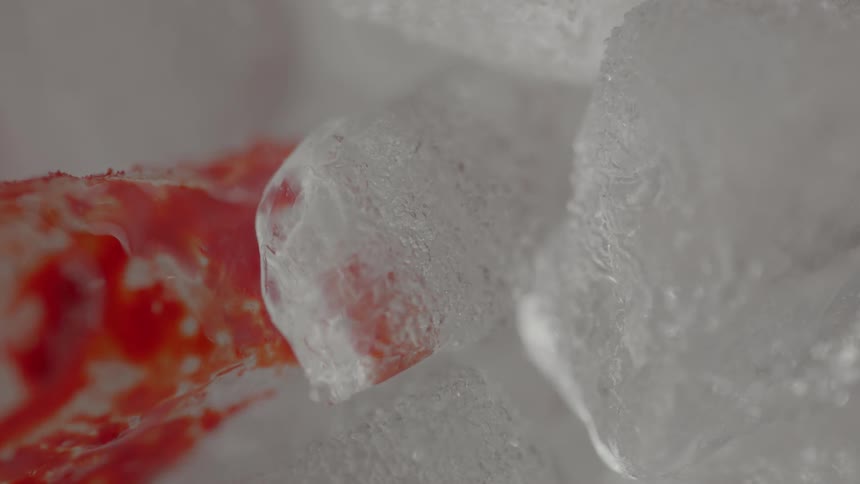 Red liquid flowing towards some white substance