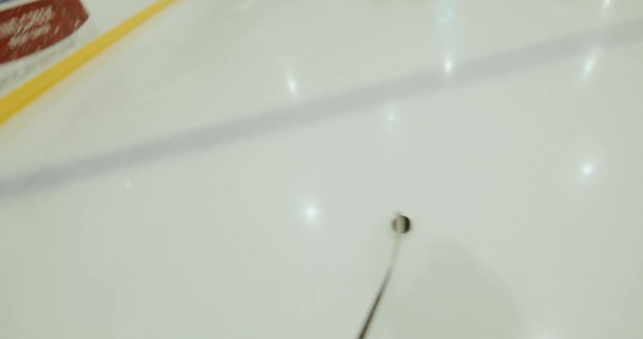 Point of view of a player driving a hockey puck on the ice