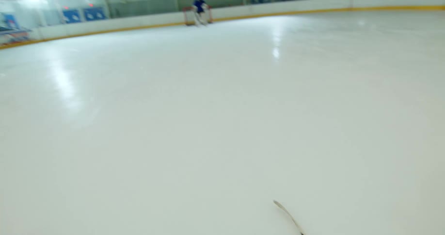 Overhead view of a hockey stick playing the puck back and forth towards the net