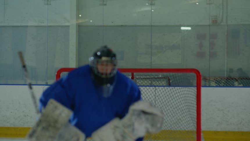 A goalie concentrated and preparing for a defense while on a hockey court