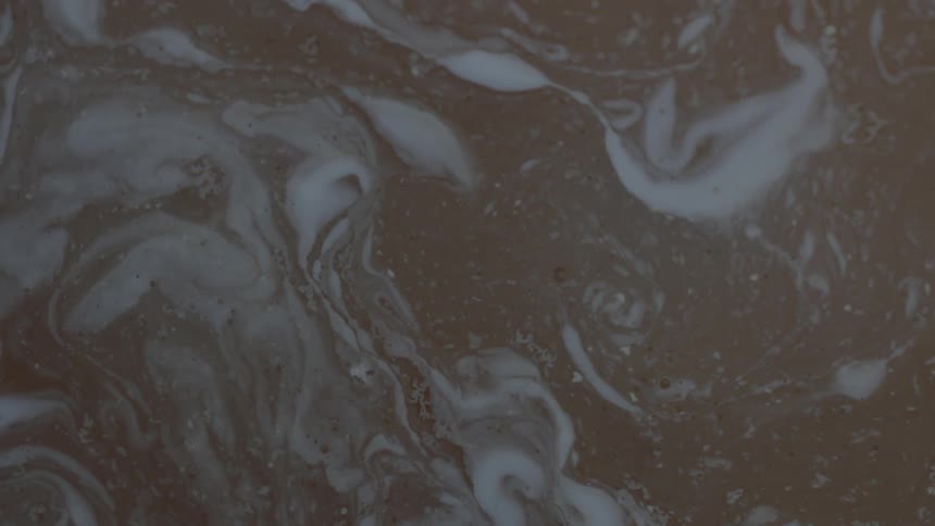 Foam and muck whirling in a puddle