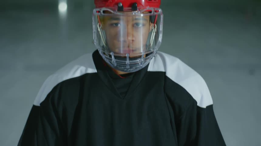 Man with a stick and helmet on the hockey court