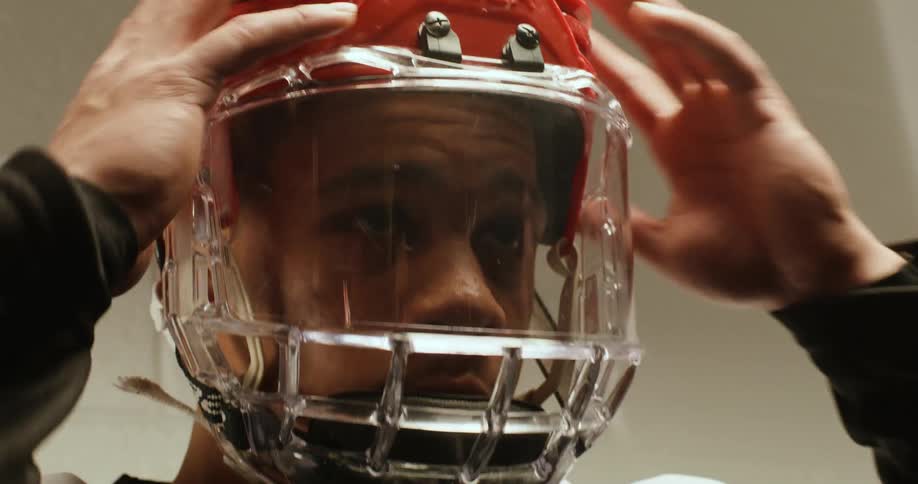 Portrait of a young man adjusting his protective sports hockey helmet