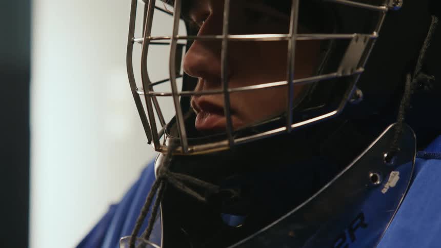 A teenager is wearing a goalie mask