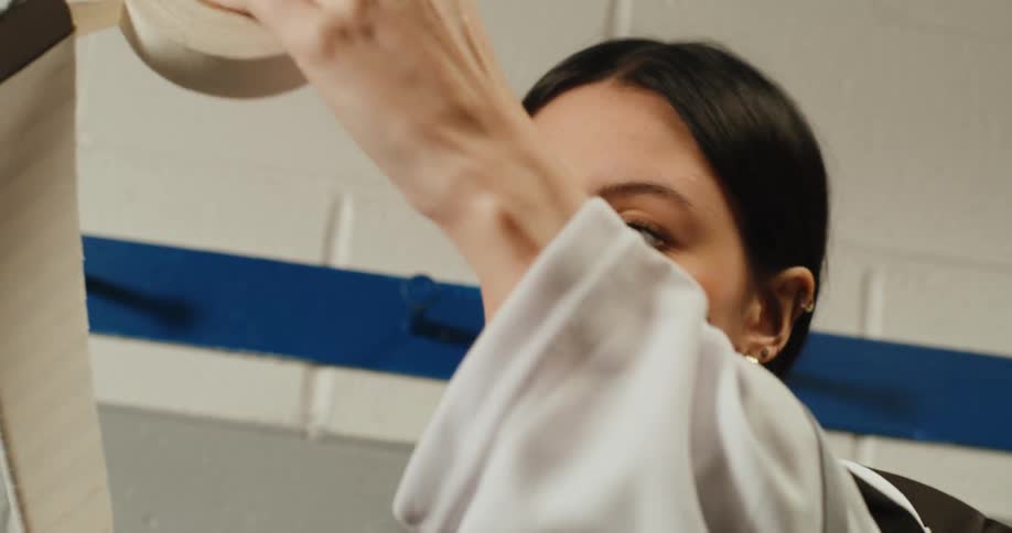 A young woman covering a hockey stick with tape