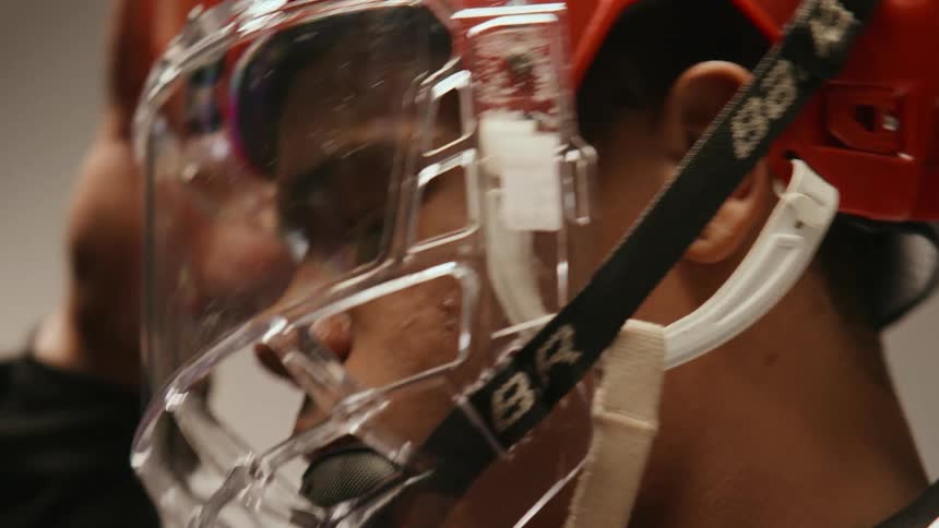 Clip of a young man adjusting his hockey helmet