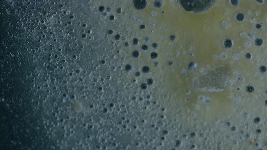 Varying sized bubbles in some liquid and some disappear