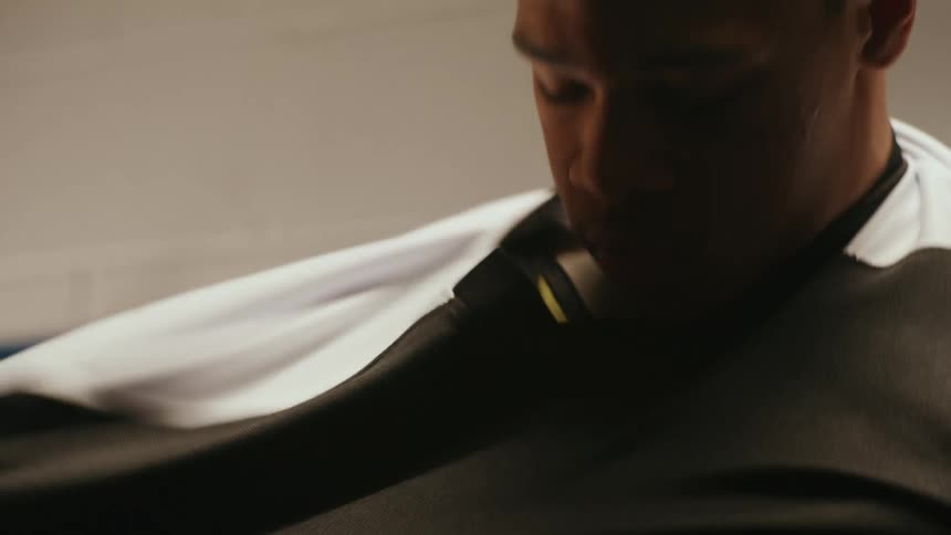 Clip of a young man putting on hockey jersey