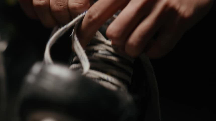 Closeup of a mans hands lacing his ice skates