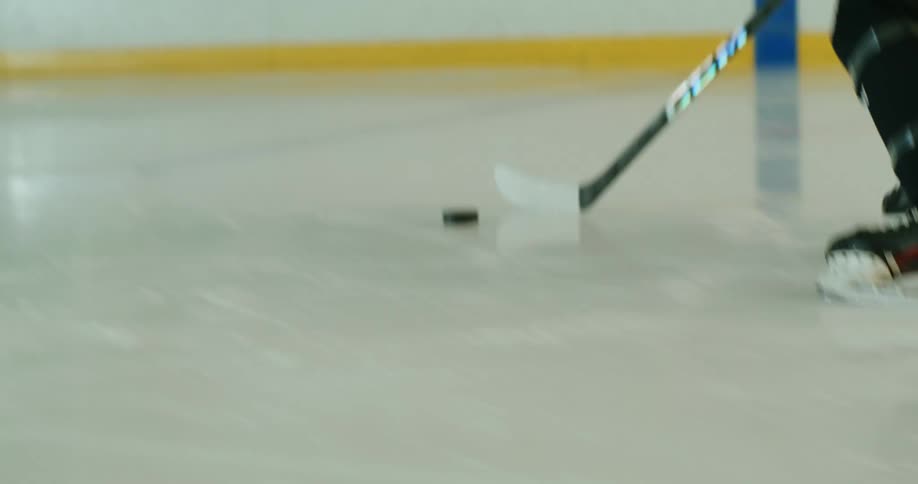 Player using their hockey stick to attempt a goal in a hockey game