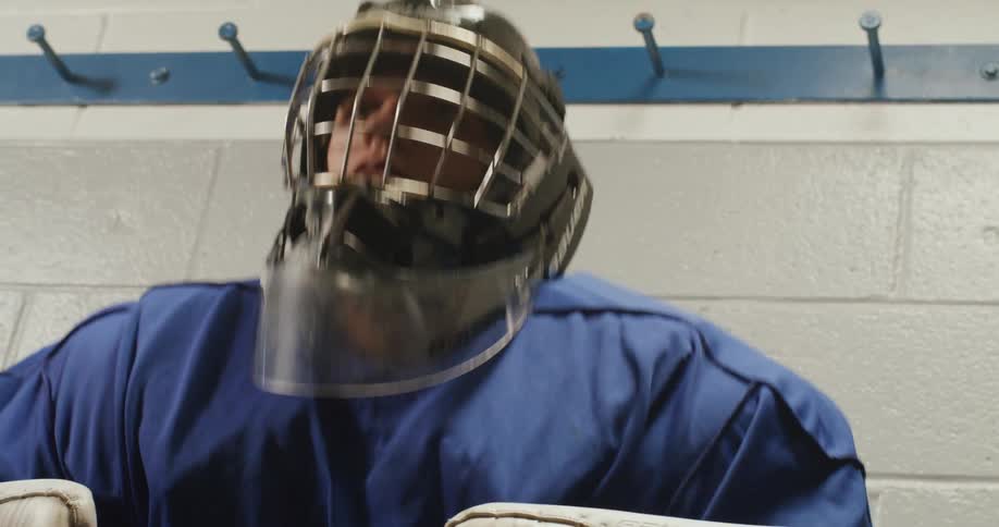Young teenager with hockey goalie helmet and clothes standing up