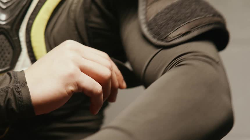 Closeup of a mans hands putting on protective hockey clothing