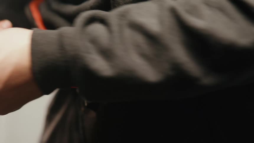 A man ties an orange belt around his waist