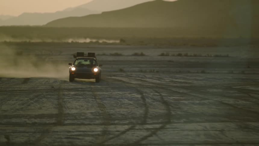 Two cars racing about on a desert