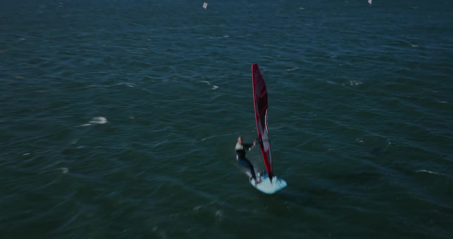 A windsurfer passes beneath the camera at full speed