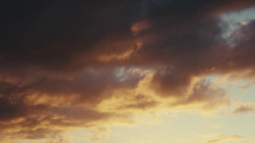 Several dark clouds passing in the sky and a part of it illuminated by sunlight