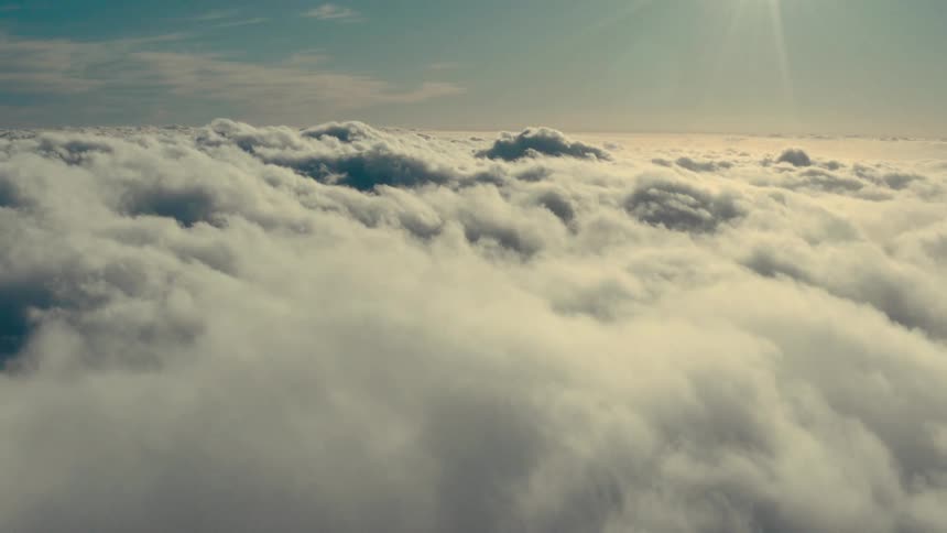 An aerial view of the sky filled with fluffy white clouds