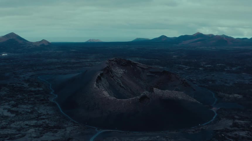 Aerial scenery of a mountain with a centered crater on a cloudy day
