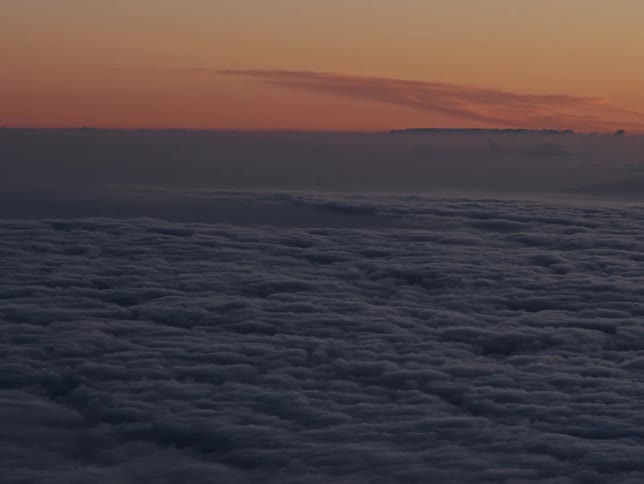 Aerial landscape of cluster of dense clouds against an orange sky