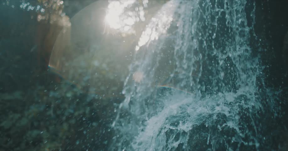 Water from a small waterfall free falling through nature