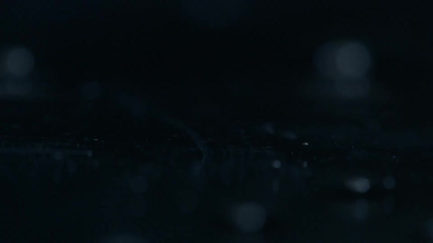 Close up of liquid bubbling in a very dark setting