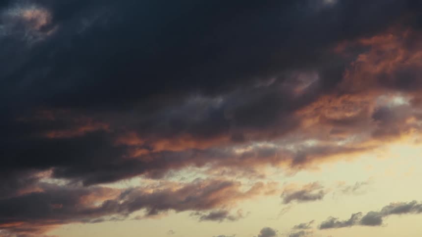 Dark clouds are moving in the sky at sunrise