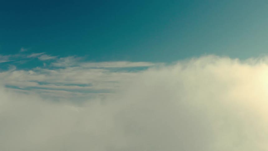 An aerial view of a cloudy sky with puffy cotton like clouds