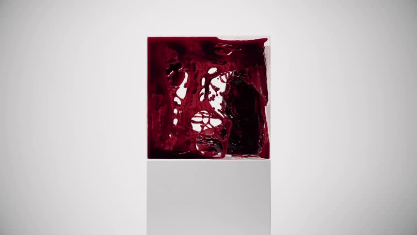 Red fluid splashes within a clear cubicle on a pedestal in a pale room
