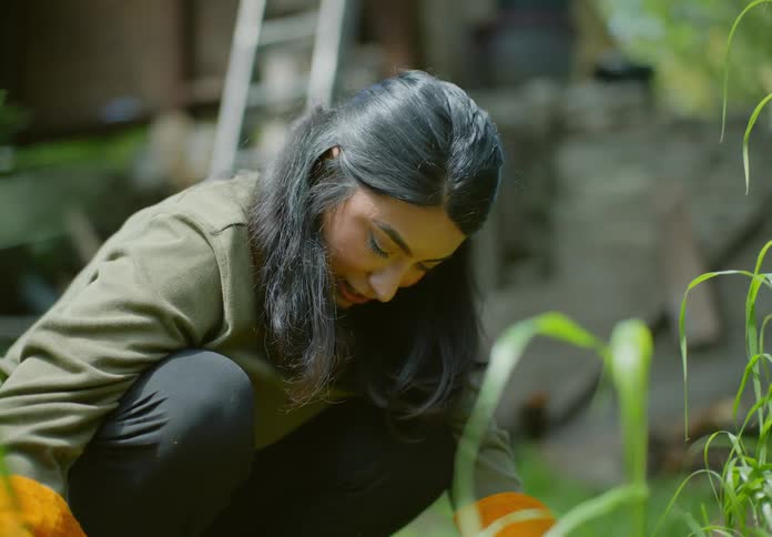 A woman talks as she works in the garden