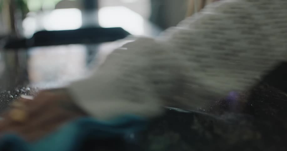 A woman is cleaning the counter