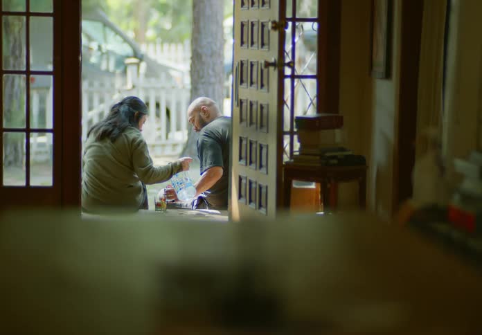 Two people are drinking water on the porch