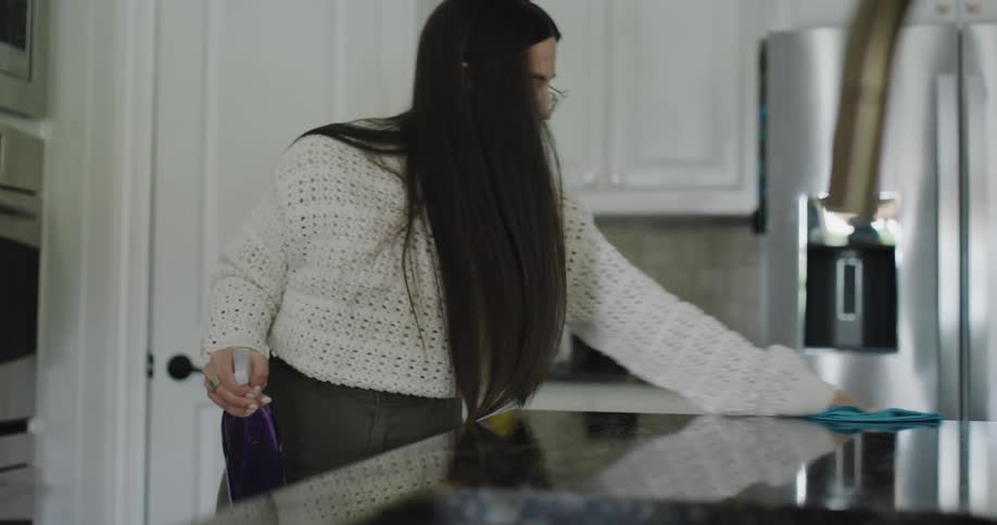 A woman is cleaning up the kitchen