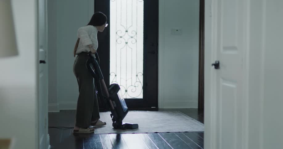 A woman is vacuuming at home