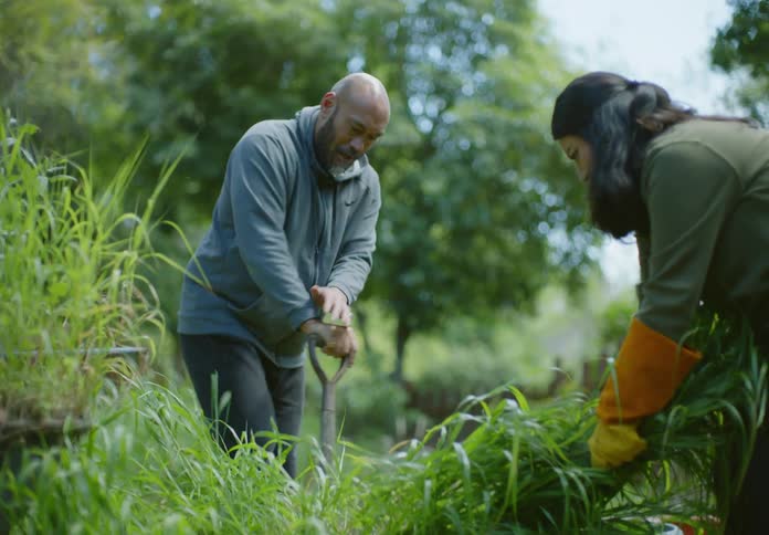 A clip of a male and female working on a garden