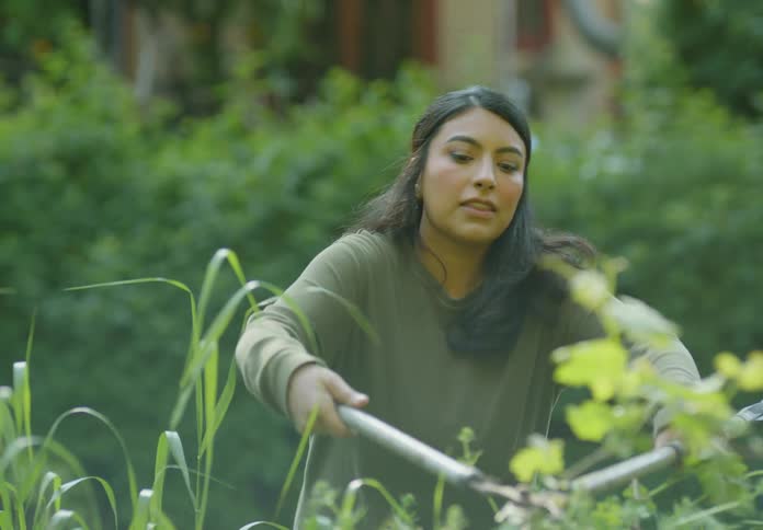 A woman tending her garden with gardening scissors