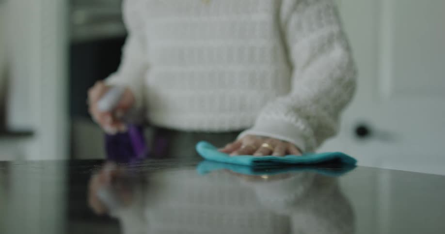 A woman is cleaning the counter