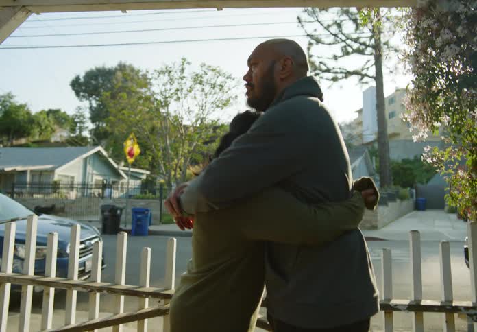 Couple near the gate of a house hugging