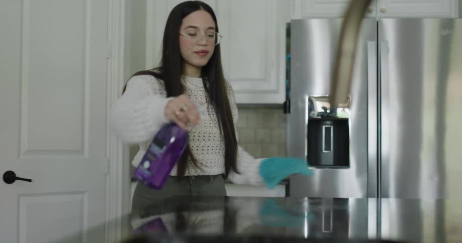 A footage of a female cleaning a table in the kitchen