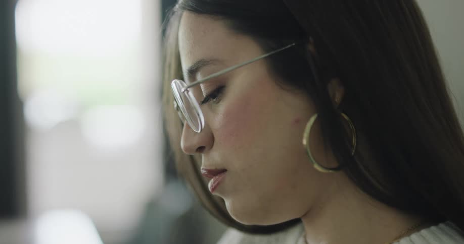 A woman is looking down at something at home