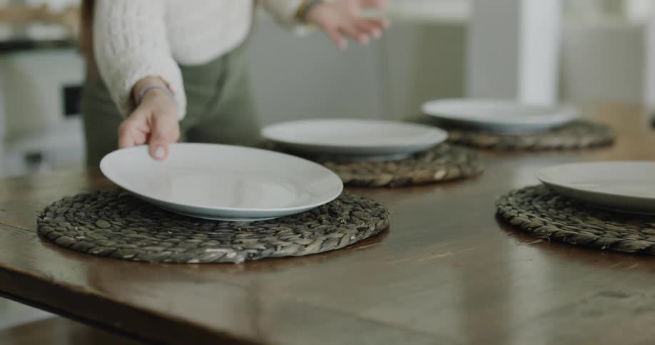 A woman sets the dining room table