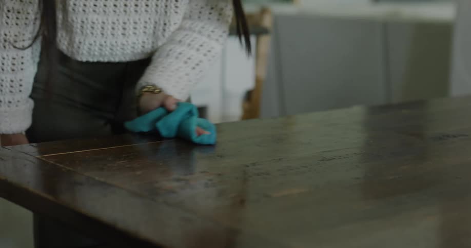 A clip of a lady cleaning a table