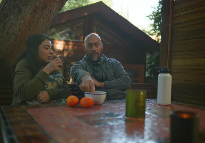 A man and woman drink and eat outside