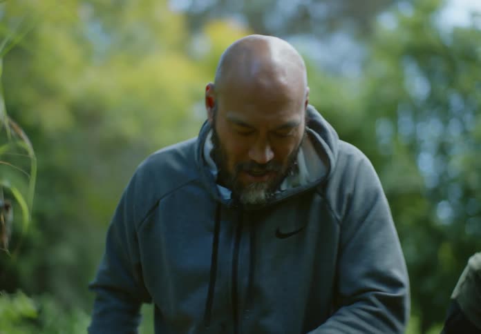 A man shovels dirt into a pot