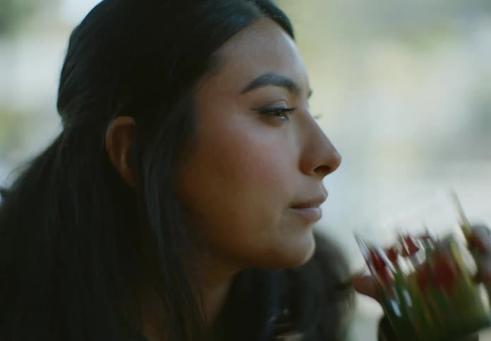 A womans face is shown drinking from a glass of water