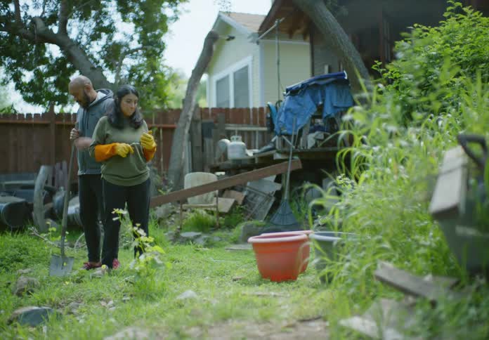 A man and woman are talking as they plan on working in their yard