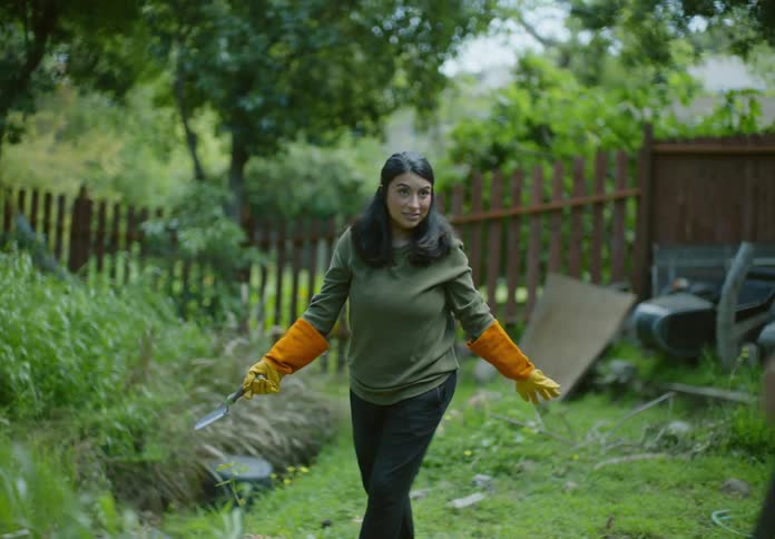 A man and woman are gardening in their yard