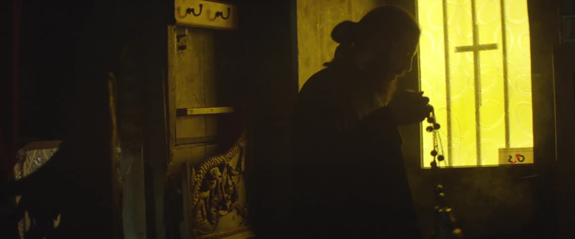 Man shakes something in a dark room it is giving off steam