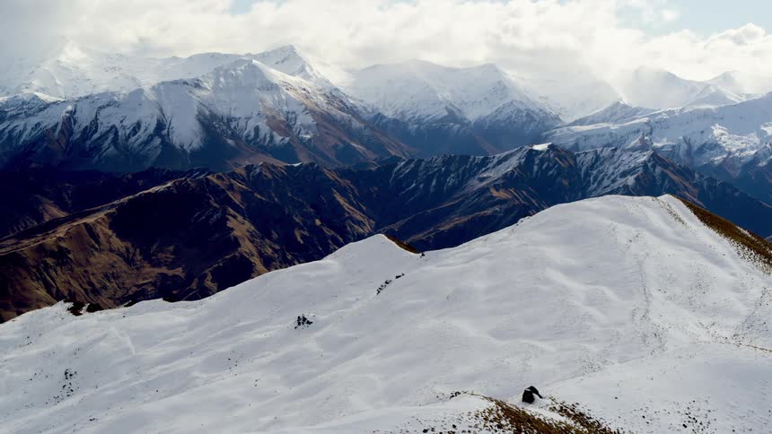 Aerial view of a snow covered ski area with background mountain ridge