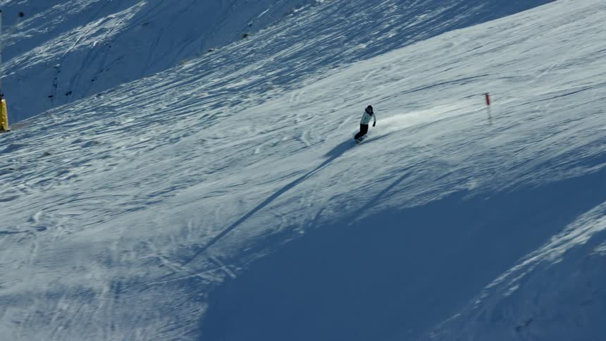 Aerial view of a person snowboarding down a snowy slope