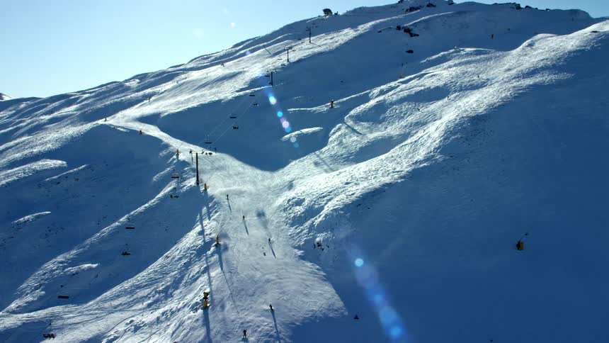 Several people skiing on a snowcovered mountain with a ski lift